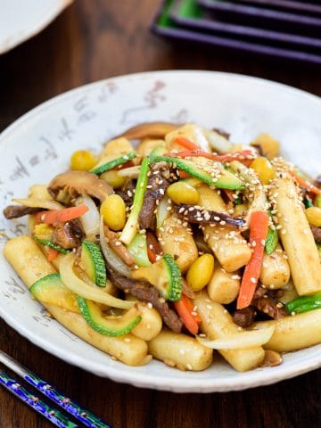 Korean finger size rice cakes stir-fried with beef, mushrooms, carrot, zucchini slices