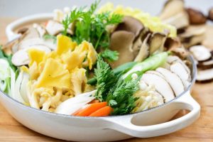 arranging an assortment of mushrooms and other vegetables for Korean hot pot