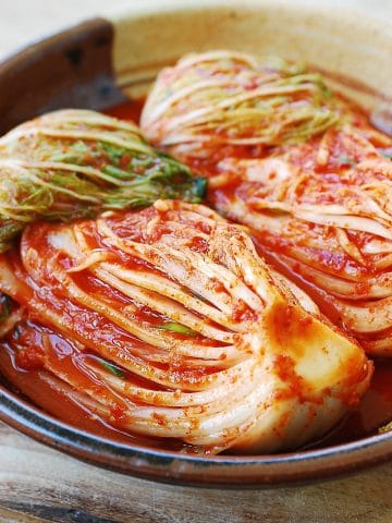 2 quarter-heads of napa cabbage kimchi in a large ceramic bowl