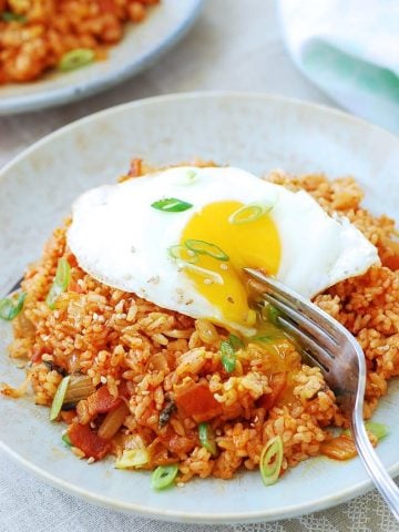 Kimchi fried rice in a large plate with a sunny side up egg