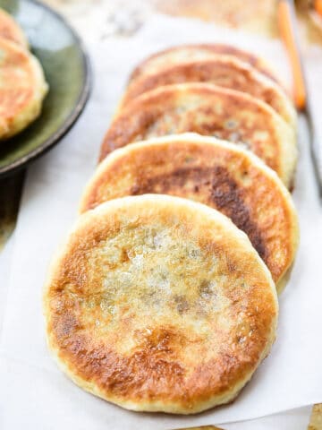 a few Hotteok (Sweet Korean Pancakes) served on a parchment paper